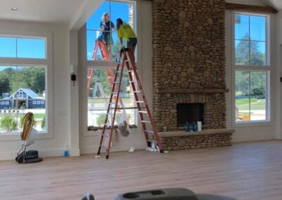 Two men are working on a fireplace in the living room.