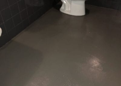 A toilet sitting in the middle of a bathroom floor.