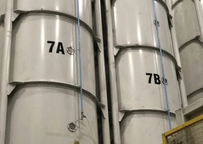 A bunch of large white tanks in a room.