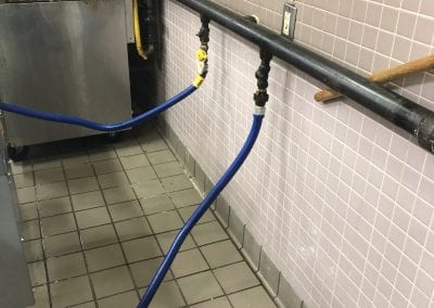 A blue hose connected to the wall of a kitchen.