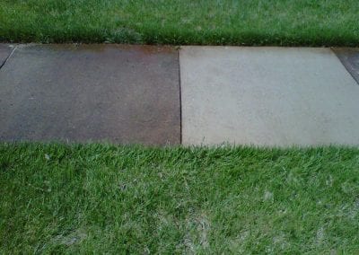 A sidewalk with grass and concrete on it.