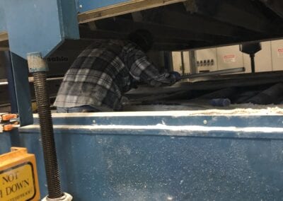 A person laying down in the middle of an industrial machine.