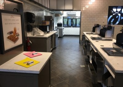 A kitchen with many counters and tables in it
