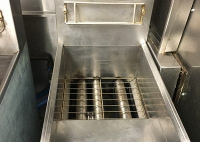 A stainless steel sink with metal grates on the bottom.