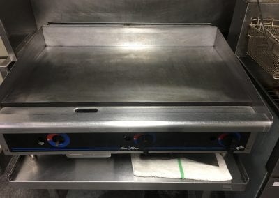A stainless steel grill sitting on top of a counter.