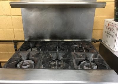 A stove with six burners and two ovens.