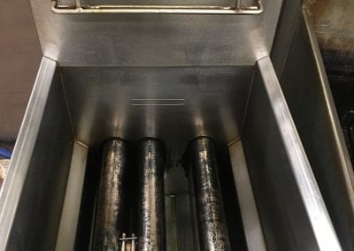 A stainless steel machine with three bottles inside.