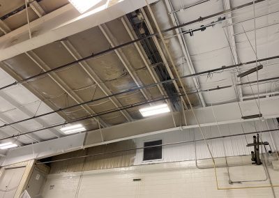 A ceiling with wires hanging from the side of it.